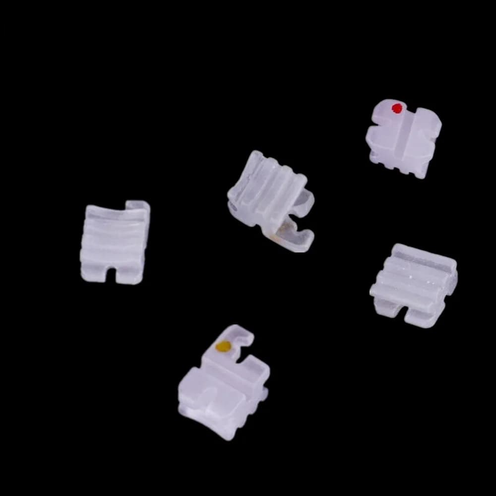 Ivory-white conventional ceramic orthodontic brackets showing front, side and base views