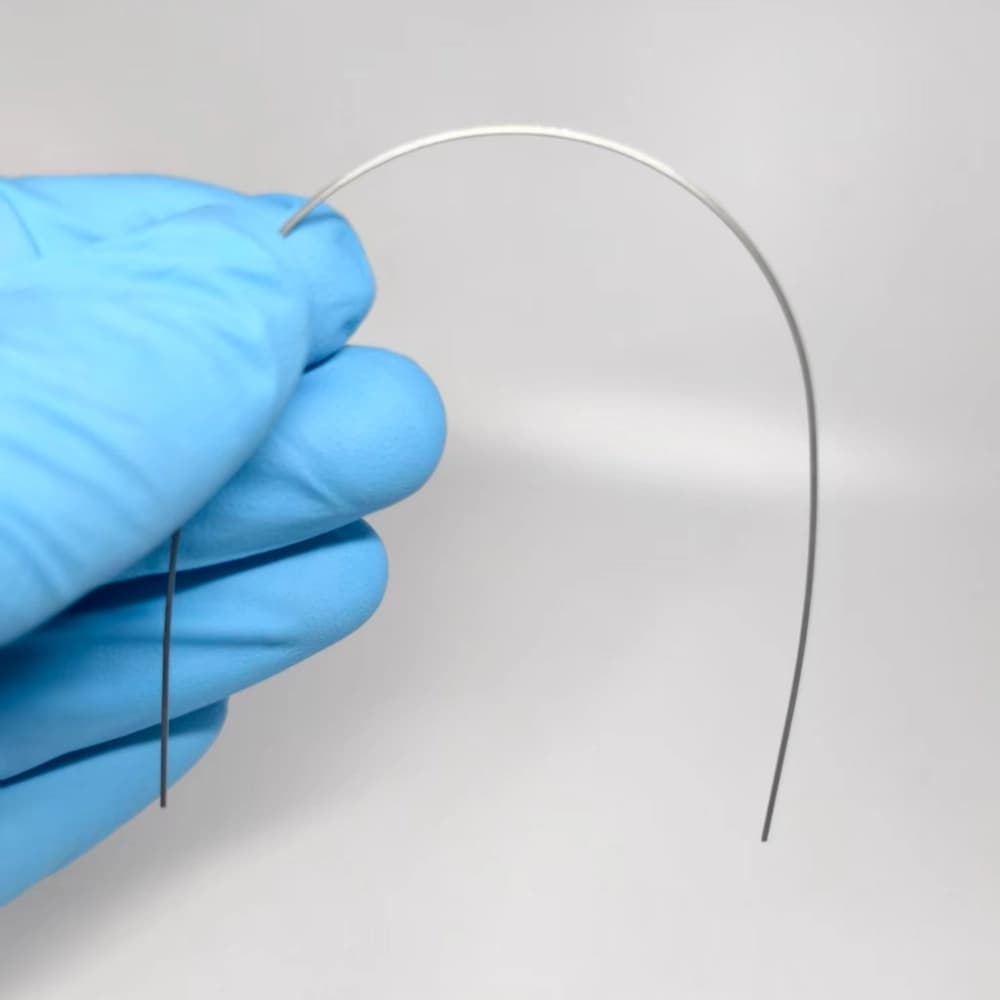 Polished copper nickel-titanium orthodontic archwire shown in a curved profile