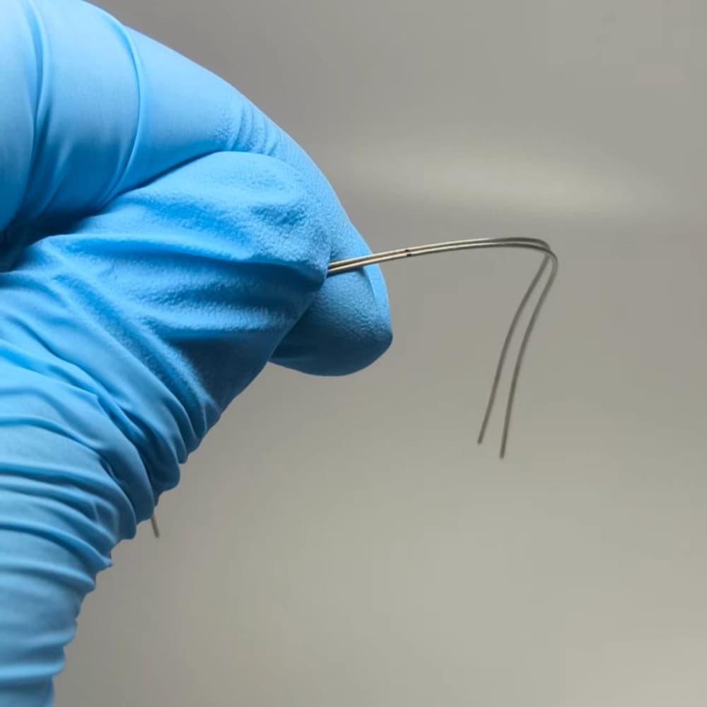 Polished NiTi reverse curve archwire with a visible centerline mark